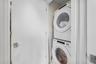 Stacked washer and dryer units within an interior utility closet
