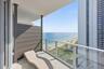 Private balcony with a glass railing, offering expansive ocean and coastline scenery