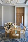 High ceilings with a contemporary chandelier, wood-paneled walls, and a recessed doorway