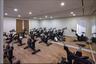 Dedicated fitness space with multiple stationary bikes, expansive wall mirrors, recessed lighting, and wood-finish flooring