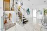 Modern staircase featuring wood treads, glass panels, and stainless steel railings