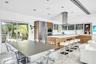 Open-concept kitchen with wood-finish cabinetry, stainless steel appliances, and a central island with a sink