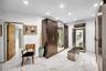 Recessed lighting, white walls, wood-finish flooring, built-in dark wood cabinetry, and a display cabinet with glass doors