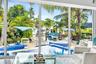 Floor-to-ceiling windows with expansive water frontage, a built-in pool, and a spa featuring blue mosaic tile