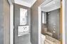 Modern bathroom featuring gray tiled walls, a wall-mounted sink with a glass shelf, and a mirror