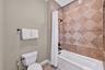 A separate room off the sink area in the Jack & Jill bath houses toilet and tub/shower combo.