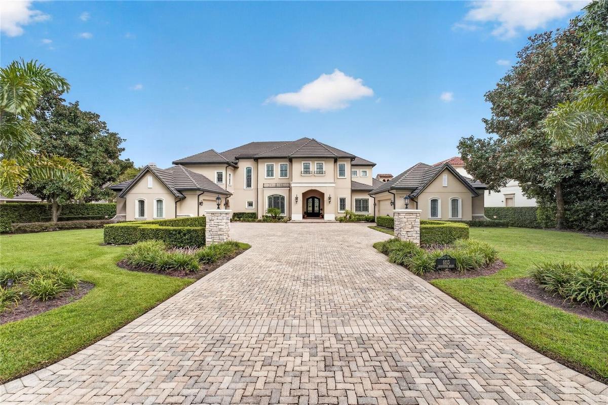 Exterior View. This home offers an extended paver drive with side parking pads and twin motor courts for garage parking for 4 vehicles + left side ent