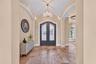 Iron and glass clad Double Door entry, barrel style ceiling with rope detail molding and chandelier bring this foyer to the next level.