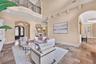 The formal living opens to casual living with access via the arched entry seen to the right as well as through the dining/bar area.