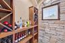 The iron gated Wine Room off the beverage bar offers built in storage and a 45 Bottle BRISA Wine refrigerator.
