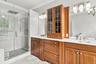 Spa-inspired luxury with dual vanities, marble finishes and a glass-enclosed shower.