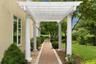 A gracious garden walkway leads beneath an impressive columned portico.
