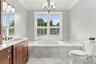A beautifully appointed ensuite with marble finishes and an elegant soaking tub.