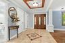 A grand introduction of hardwood floors, architectural columns and dentil molding.