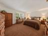 Virtually staged primary bedroom showcasing the spacious layout, natural light, and potential for a dedicated work area.