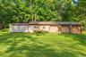 Virtually enhanced exterior view highlighting the detached garage, multiple bays, and spacious surrounding grounds.