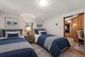 Virtually staged bedroom showcasing a twin-bed layout with space for a dedicated desk or study area.