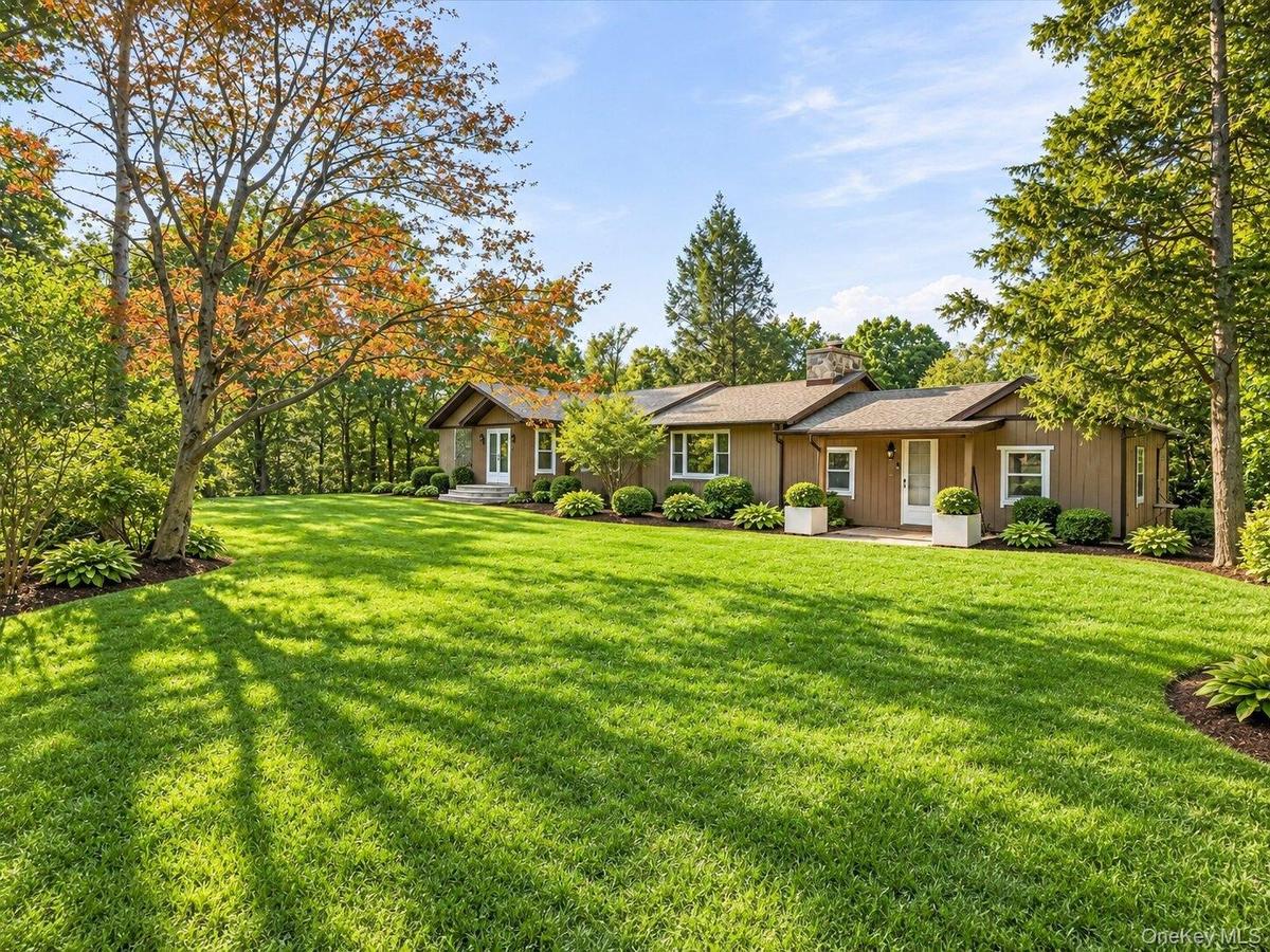 Virtually Staged. Attractive single-level home surrounded by lush landscaping and a beautifully maintained front yard.