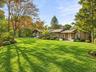 Virtually Staged. Attractive single-level home surrounded by lush landscaping and a beautifully maintained front yard.