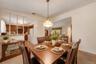 Virtually Staged. Dining area with a classic light fixture, generous table space, and easy flow into the kitchen and living room.