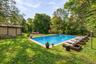Virtually staged pool area highlighting the lounge space, surrounding greenery, and outdoor entertaining potential.