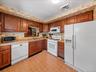 Full kitchen view featuring extensive wood cabinetry, ample counter space, and a practical appliance layout.