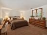Virtually staged primary bedroom demonstrating the room’s generous dimensions and flexible furniture placement.
