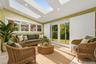 Virtually staged sunroom highlighting the skylights, garden views, and generous space for relaxing or entertaining.