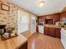 Virtually decluttered kitchen showcasing the generous counter space, cabinetry, and convenient exterior access