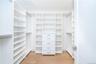 Spacious closet with light hardwood / wood-style flooring