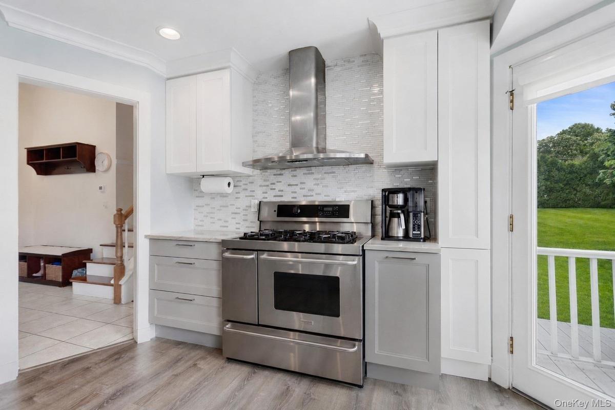 Kitchen with stainless steel range and tile backsplash.