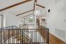 Open-plan great room w/ hardwood floors, exposed wood beams, and fresh paint.