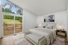 Virtually staged primary bedroom with brand new floors, en-suite bathroom, & walk-in closet.