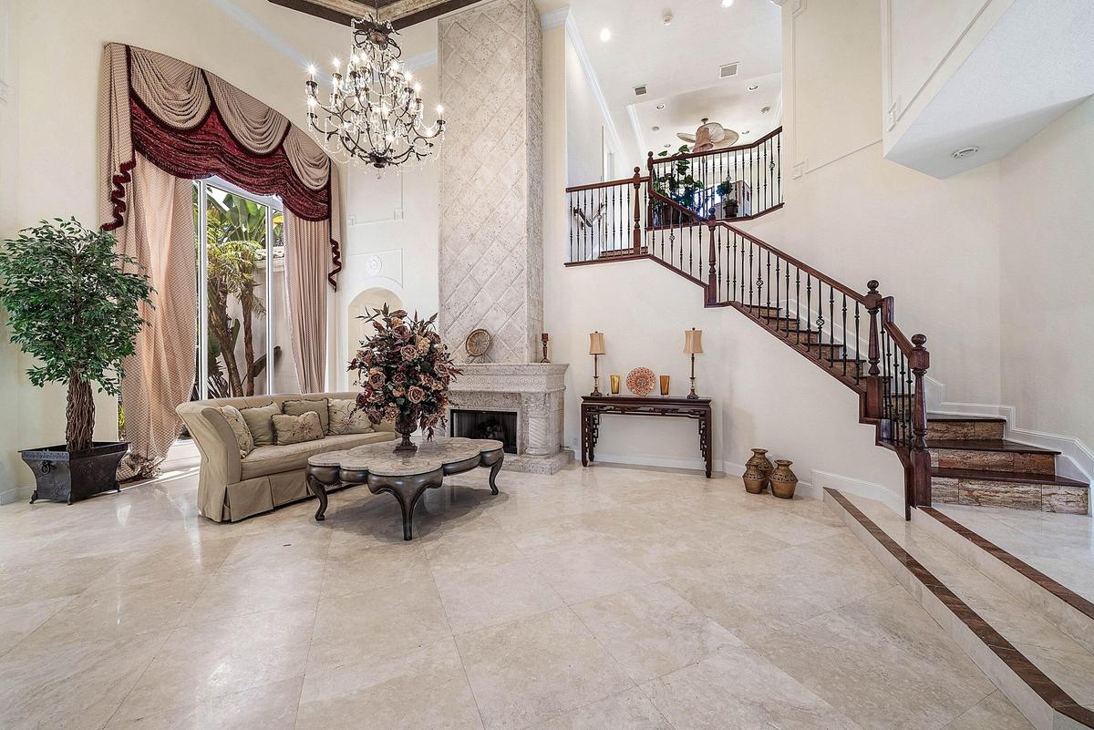 Two-story living room with marble flooring and a grand gas fireplace