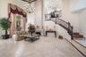 Two-story living room with marble flooring and a grand gas fireplace