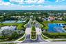 Gated community (24/7 manned) entrance with surrounding water features, and lush landscaping