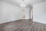 Wood-finish flooring, crown molding, white paneled doors leading to shared bathroom