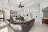 Tray ceilings with recessed lighting, built-in entertainment center, integrated shelving with arched alcoves.