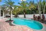 Paver patio surrounding a freeform swimming pool
