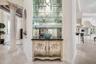 Built-in wet bar with glass shelving, mirrored backing