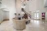 Two-story living room with marble flooring and a grand gas fireplace