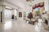 Soaring ceilings, polished marble flooring, stone fireplace, decorative columns.