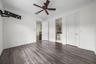 En-Suite bedroom #3 with wood-finish flooring throughout, crown molding, and a ceiling fan