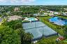 Two Resurfaced Har-Tru like tennis courts with perimeter fencing and floodlights for evening tennis, a swimming pool with a surrounding paved deck, a 