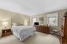 Wall-to-wall carpeting, dual windows with white trim, and neutral wall tones