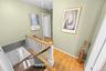 Second floor. Hardwood flooring, painted walls, white trim, wood handrail, spindle staircase