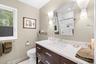 Second full bath. Single vanity with a white countertop and integrated sink, dark wood-finish cabinetry, and chrome fixtures.