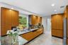 Sophisticated kitchen featuring warm wood-finish cabinetry with sleek black countertops, stainless steel appliances