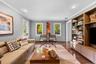 Sophisticated living room showcasing hardwood flooring, recessed ceiling lighting, and expansive windows framing natural light