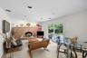 Exposed brick fireplace with hearth, recessed lighting, carpeted flooring, and sliding glass door